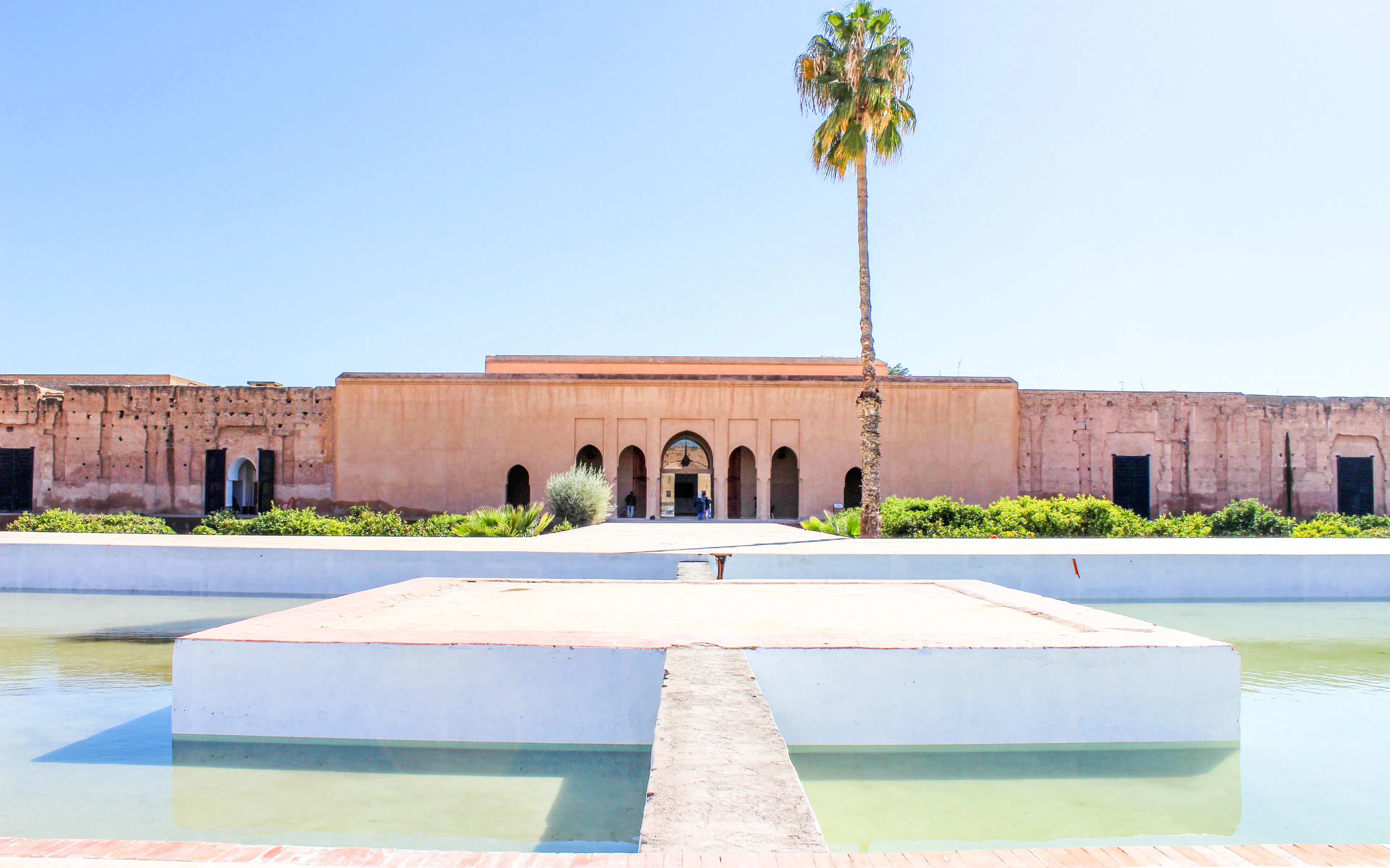 El Badi Palace courtyard with reflecting pool and palm tree, Marrakech.