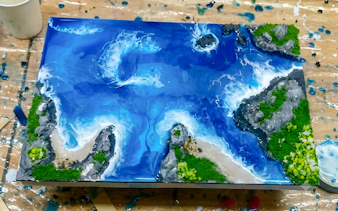 Miniature ocean scene artwork with waves and rocky shores, part of a creative experience in Hanoi.