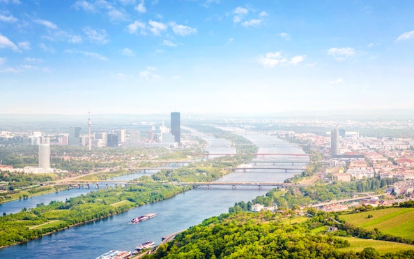 Aerial view of the Danube River and Donauinsel in Vienna, Austria, with cityscape and bridges.