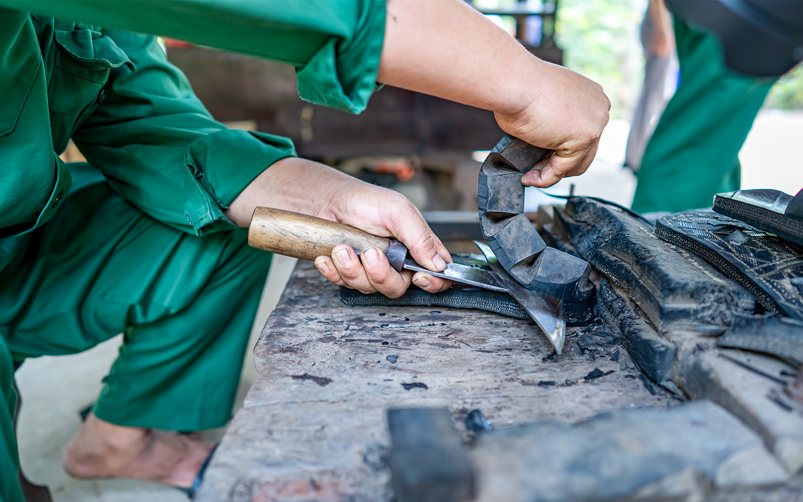 Crafting rubber slippers from car tire at Cu Chi tunnel, Vietnam.