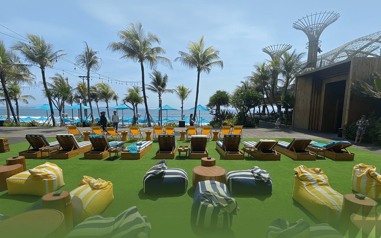 Sun loungers and palm trees at Atlas Beach Club overlooking the ocean.