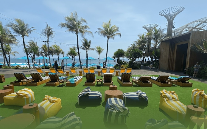 Sun loungers and palm trees at Atlas Beach Club overlooking the ocean.