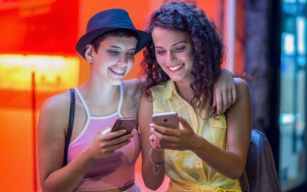 Girls using smartphones for Red Light District audio tour.