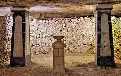 Sepulchral lamp in the Catacombs’ ossuary, Paris, surrounded by skulls and bones.