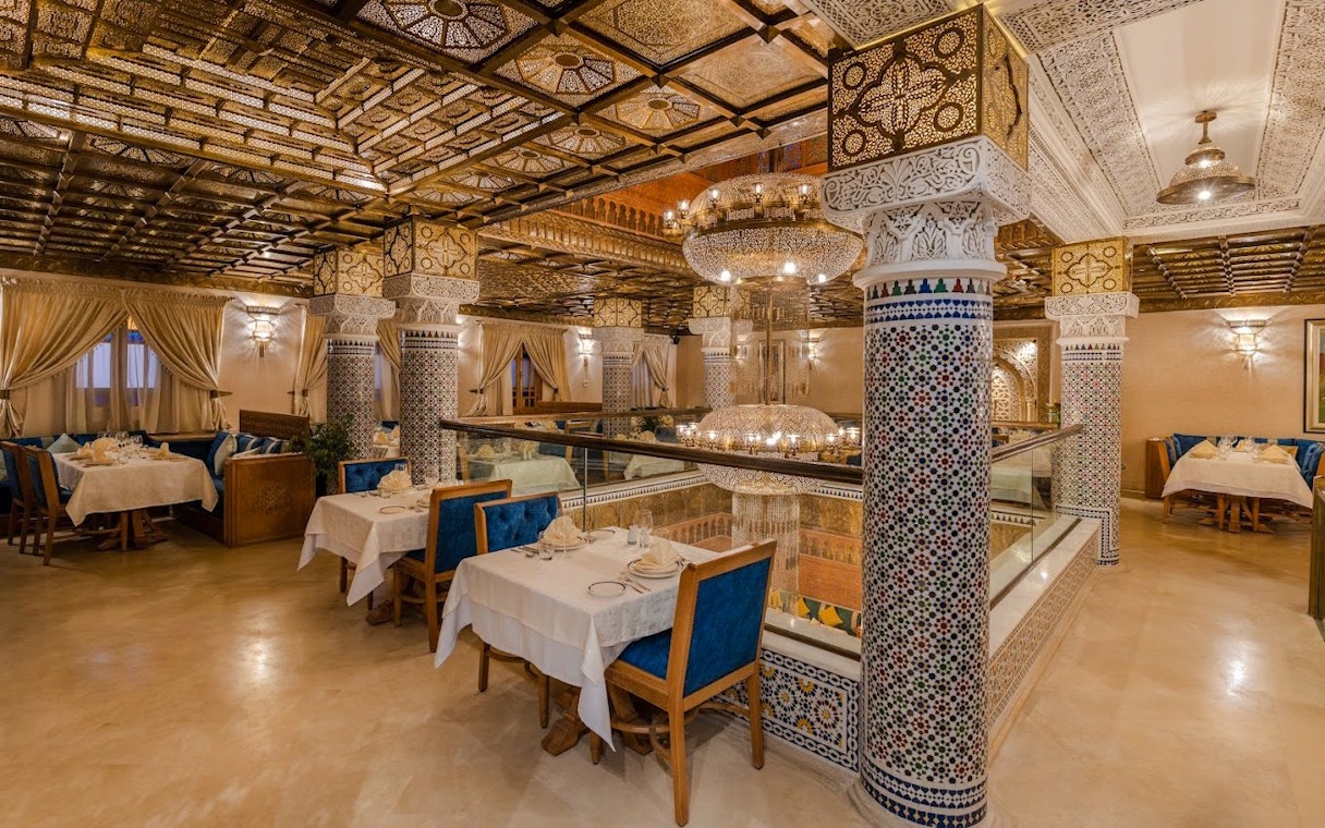 Elegant Moroccan restaurant interior with ornate columns and chandeliers in Casablanca, Morocco.