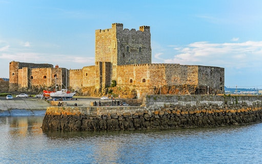Carrickfergus Castle by the water, featured in Game of Thrones location tour.
