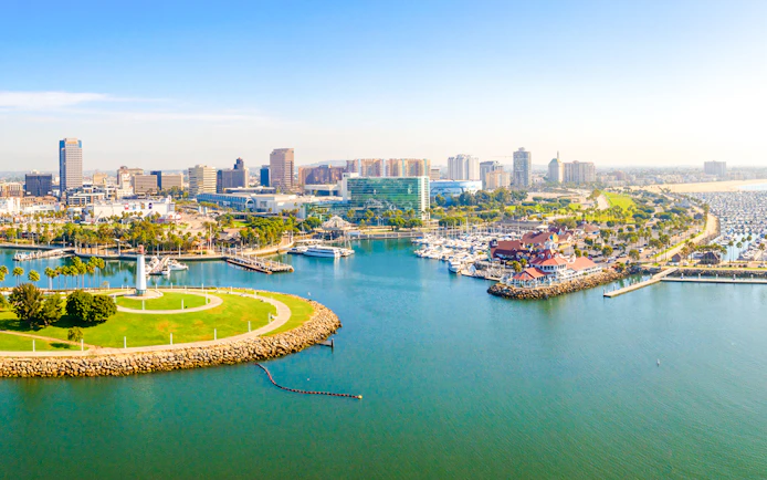 Aerial view of Long Beach coastline, harbor, skyline, and marina with boats and green park.
