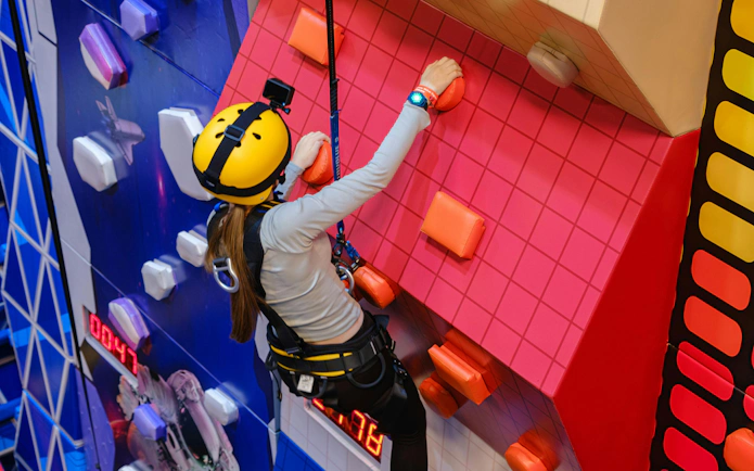 Wall climbing activity at Loco Bear, Dubai with colorful holds and safety gear.