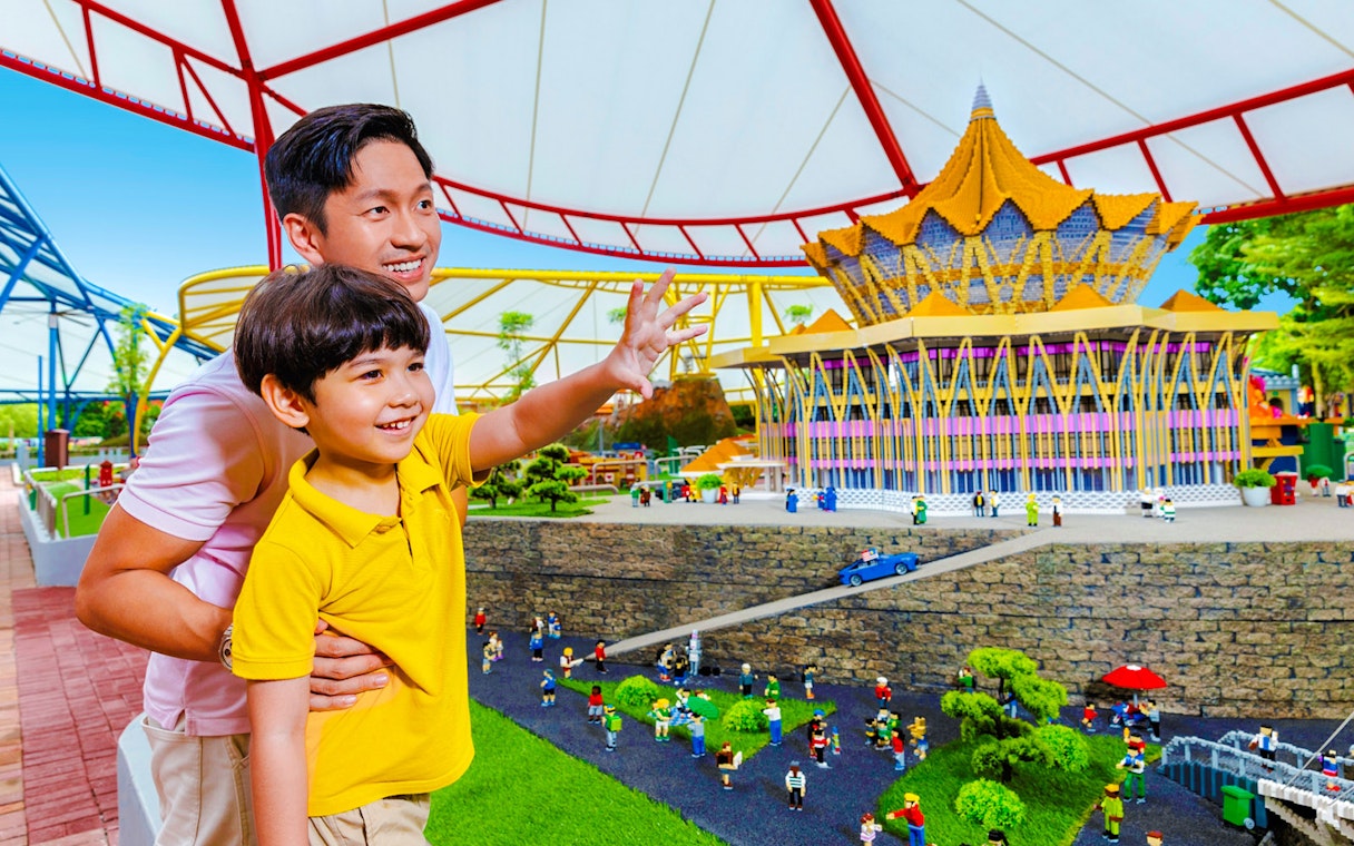 Father and son enjoying a miniature display at Legoland Malaysia theme park.