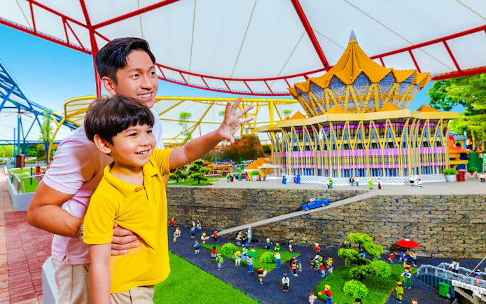Father and son enjoying a miniature display at Legoland Malaysia theme park.