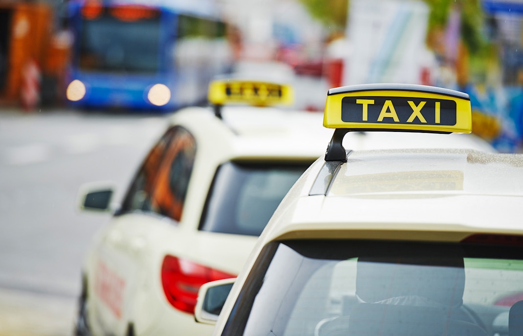 Yellow taxi driving on a road with scenic views of Phillip Island Nature Parks.