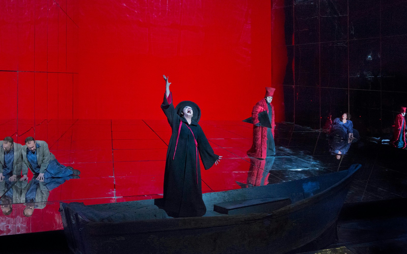 Opera scene from "Die Frau Ohne Schatten" with performers on a red-lit stage.