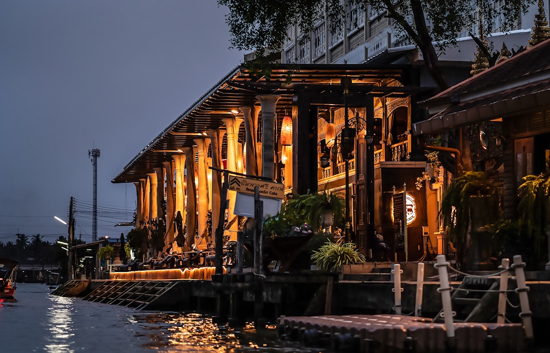 Cafe lit up at night along the canal in Thailand