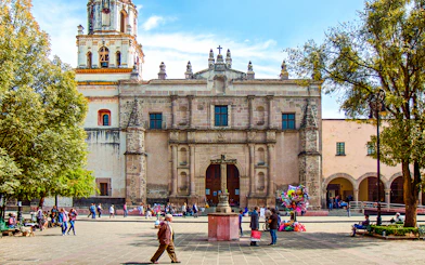 Parroquia San Juan Bautista facade with people in plaza, Mexico.