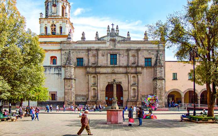 Parroquia San Juan Bautista facade with people in plaza, Mexico.