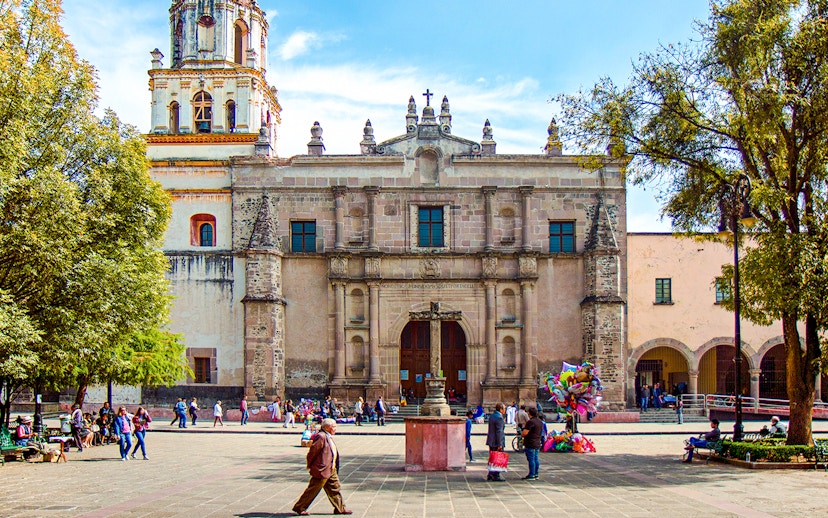Parroquia San Juan Bautista facade with people in plaza, Mexico.