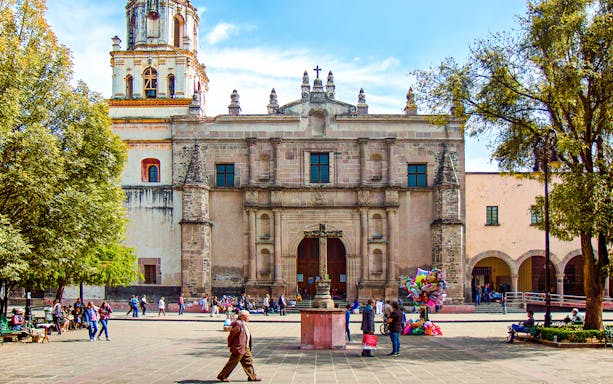 Parroquia San Juan Bautista facade with people in plaza, Mexico.