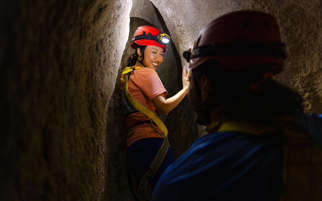 Adventurers exploring a narrow cavern in Rainforest Wild ASIA.