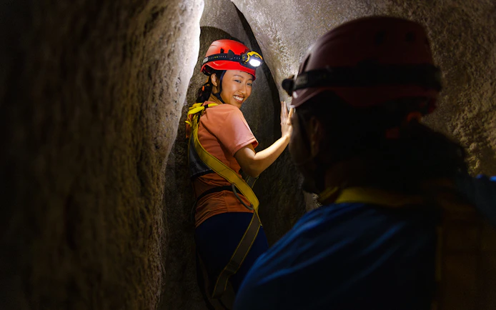 Adventurers exploring a narrow cavern in Rainforest Wild ASIA.