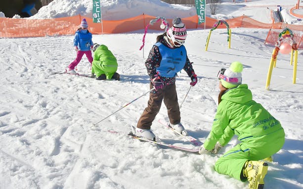Children learning to ski with an instructor at Greenpia Onuma Ski Resort.