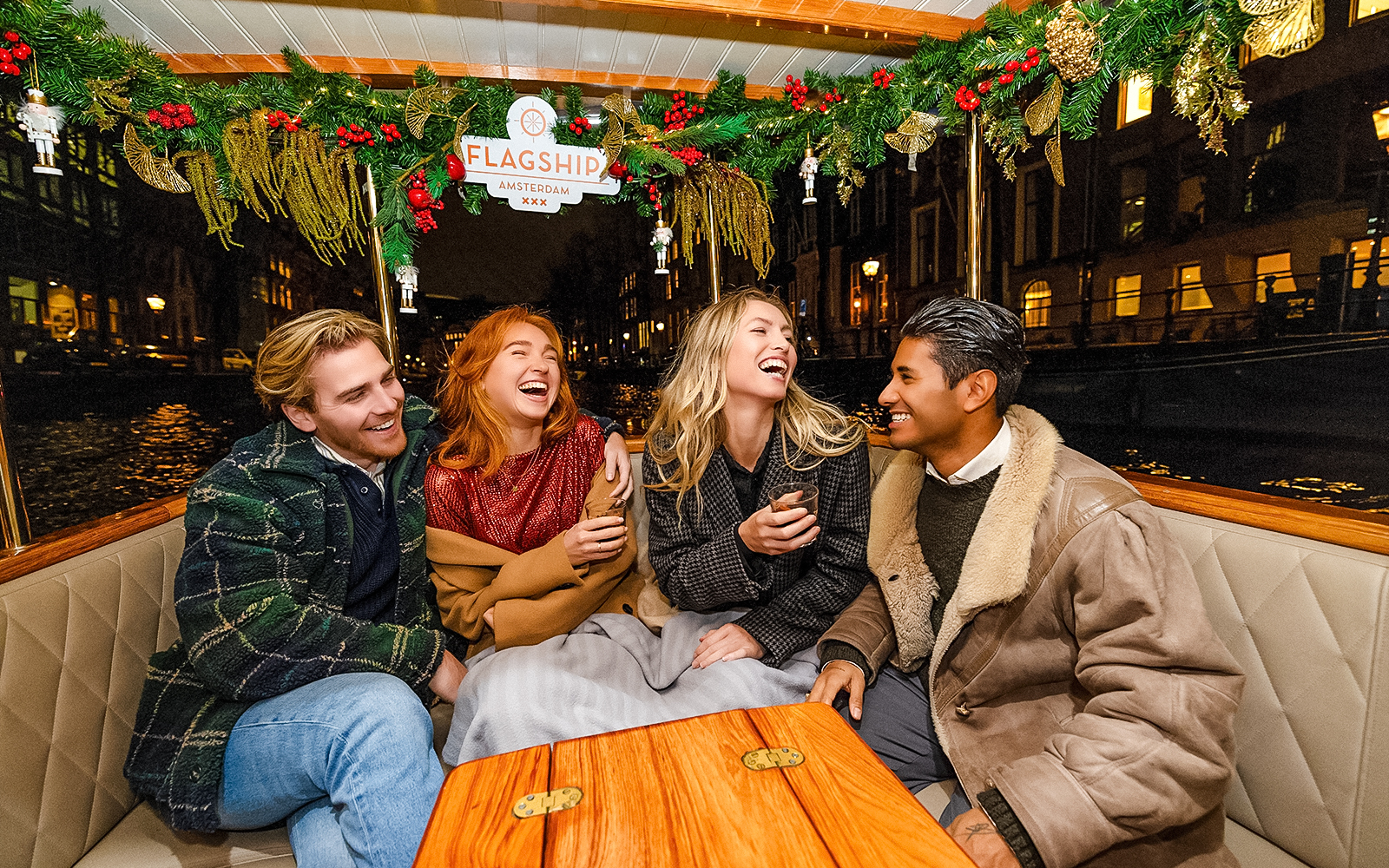 Friends enjoying Amsterdam Light Festival cruise at night.