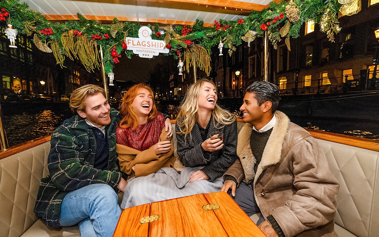 Friends enjoying Amsterdam Light Festival cruise at night.