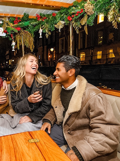 Friends enjoying Amsterdam Light Festival cruise at night.