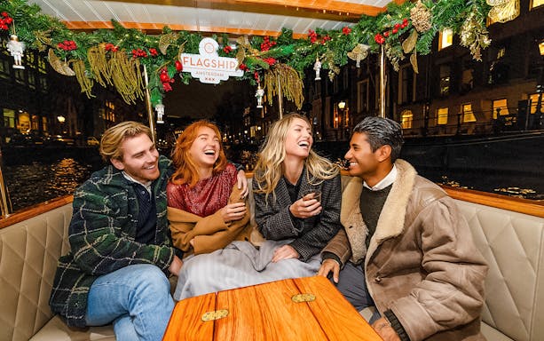 Friends enjoying Amsterdam Light Festival cruise at night.