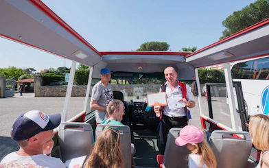 Tour guide speaking to visitors on a bus at Catacombs of Domitilla, Rome.
