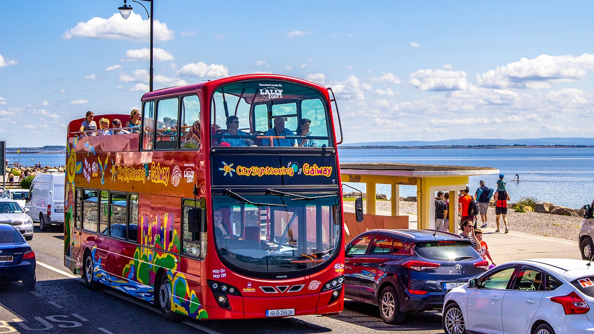 Tourists enjoying the Galway Hop-On-Hop-Off Tour with a view of the city's historic architecture and vibrant streets in Ireland