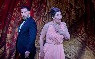 Actors performing a scene from My Fair Lady on stage with ornate backdrop.