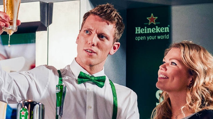 Heineken Experience guide demonstrating beer pouring in Amsterdam.