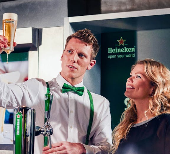 Heineken Experience guide demonstrating beer pouring in Amsterdam.