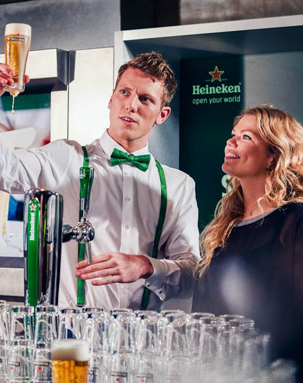 Heineken Experience guide demonstrating beer pouring in Amsterdam.