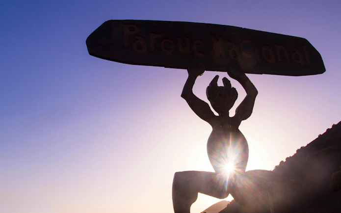 Silhouette of El Diablo statue at Timanfaya National Park during sunset.