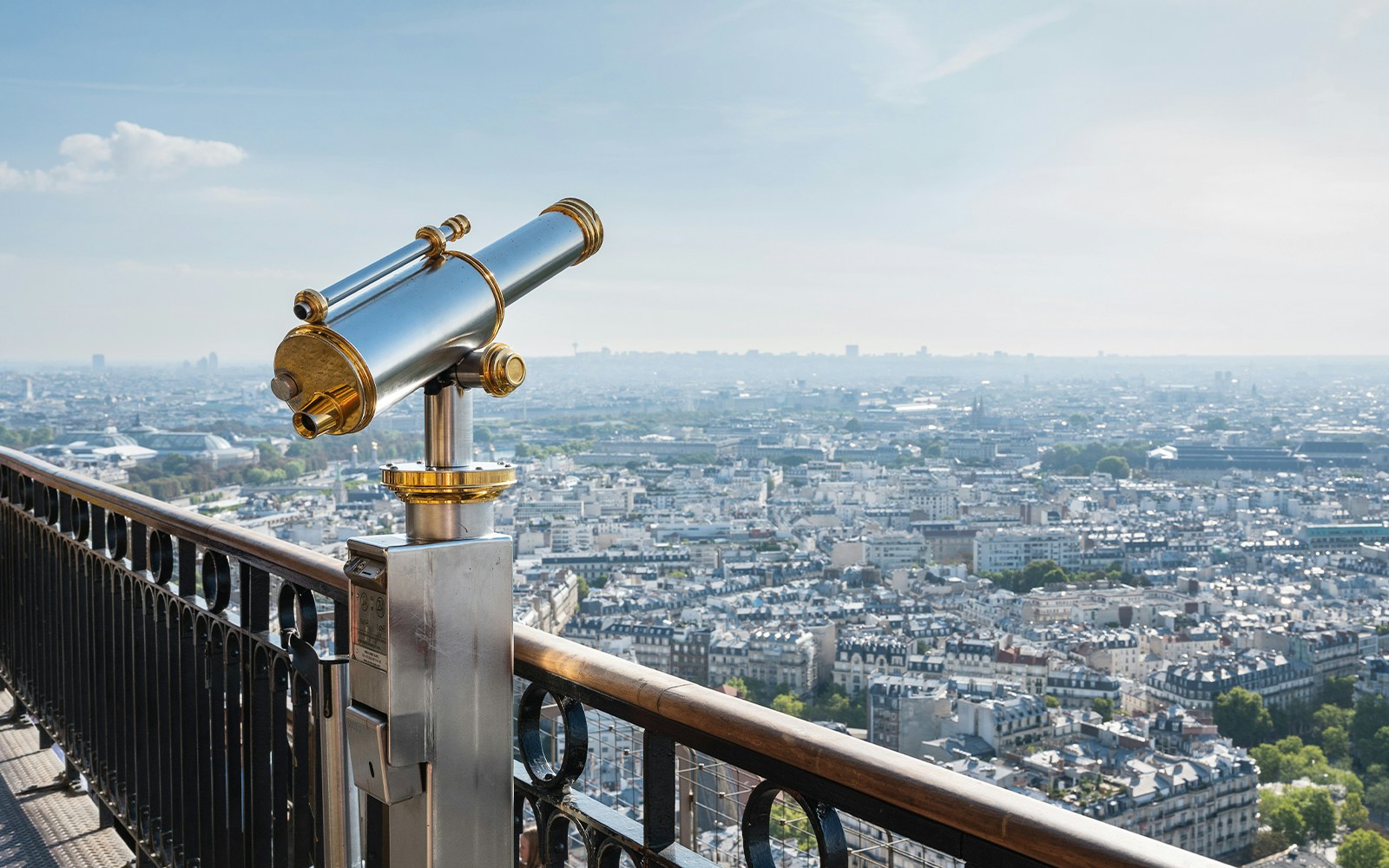 Gold-silbernes Fernglas auf der zweiten Ebene des Eiffelturms in Paris mit Blick auf die Stadt