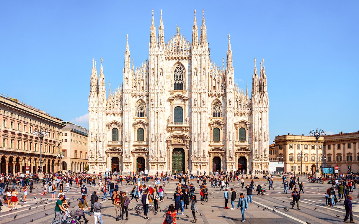 Duomo di Milano Cathedral exterior with visitors in the square, Milan, Italy.