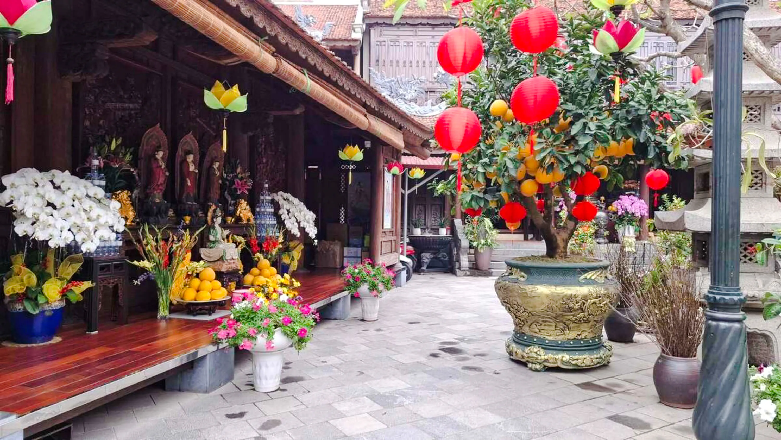 Pagoda courtyard with red lanterns and fruit offerings, Hanoi Vegan Cooking Class.