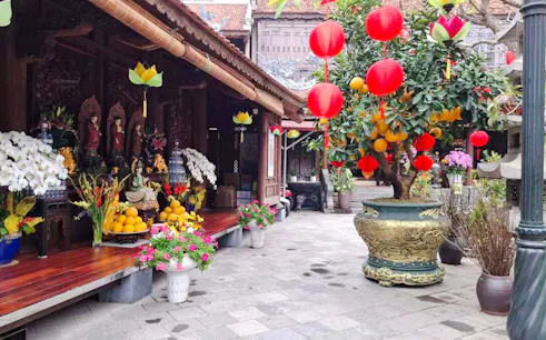 Pagoda courtyard with red lanterns and fruit offerings, Hanoi Vegan Cooking Class.