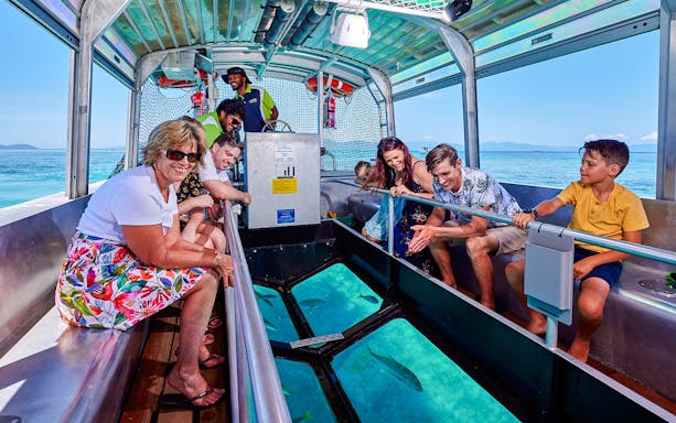 Tourists enjoying a glass-bottom boat tour near Fitzroy and Green Islands.