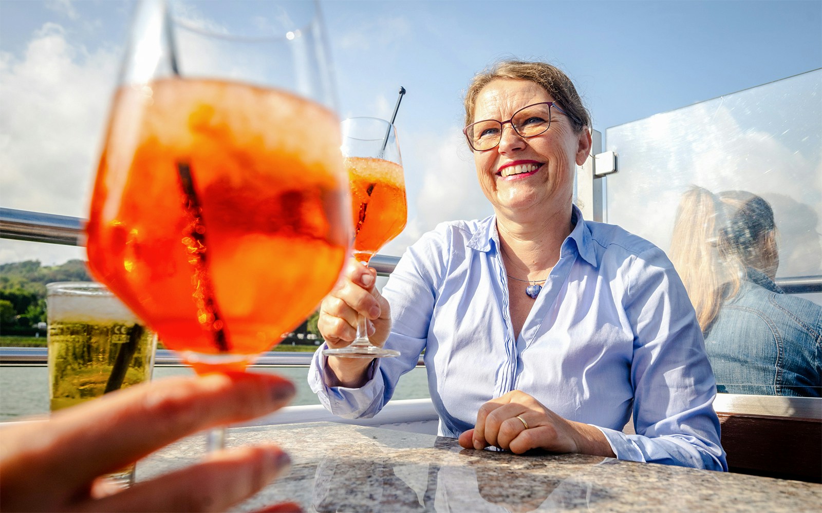 Koblenz sightseeing cruise with passengers enjoying drinks on the Rhine River.