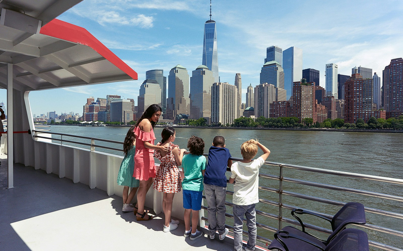 Tourists enjoying the Circle Line: 2hr NYC Harbor Lights Cruise with a view of the illuminated New York skyline at dusk