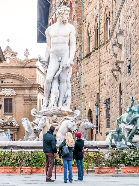 Neptune Fountain in Piazza della Signoria, Florence, with tourists observing.
