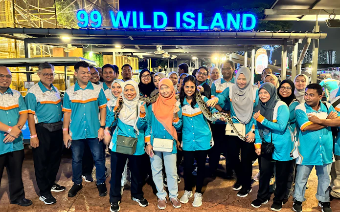 Group of people at 99 Wonderland Park entrance, Kuala Lumpur, holding a snake.