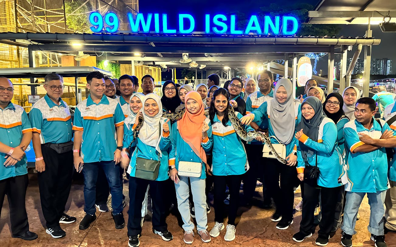 Group of people at 99 Wonderland Park entrance, Kuala Lumpur, holding a snake.