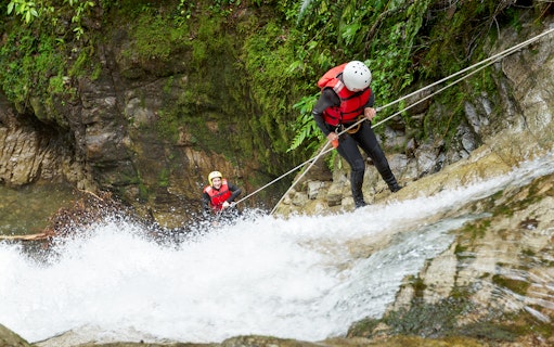 Canyoning participants descending a waterfall in Chli Schliere near Interlaken.