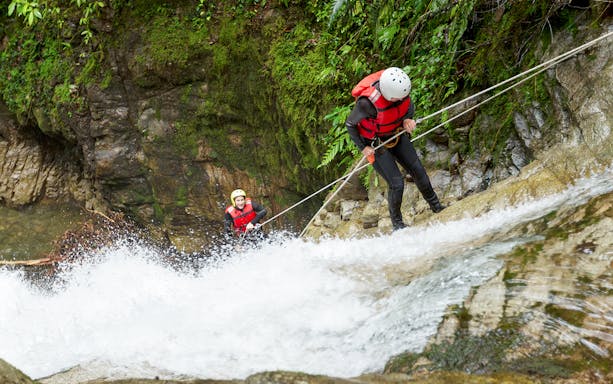 Canyoning participants descending a waterfall in Chli Schliere near Interlaken.