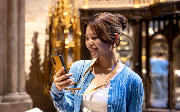 Visitor enjoying audio guide at Warner Bros. Studio Tour Tokyo - The Making of Harry Potter.