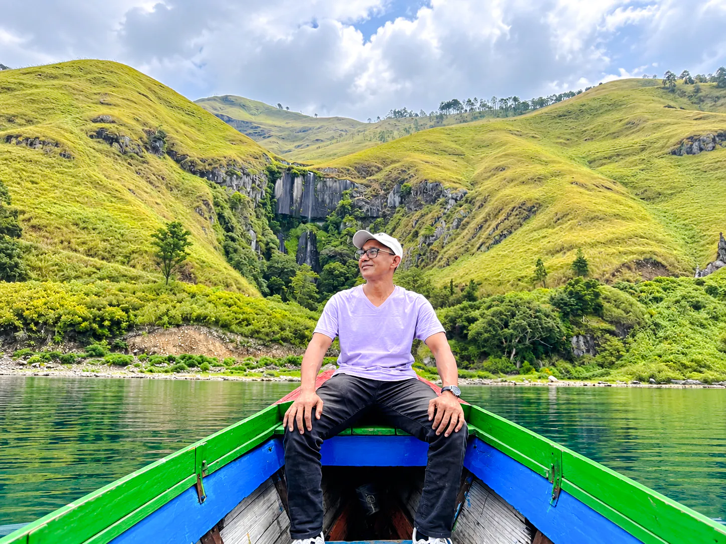 Boat trip on Lake Toba with view of waterfalls and lush hills, Medan day tour.
