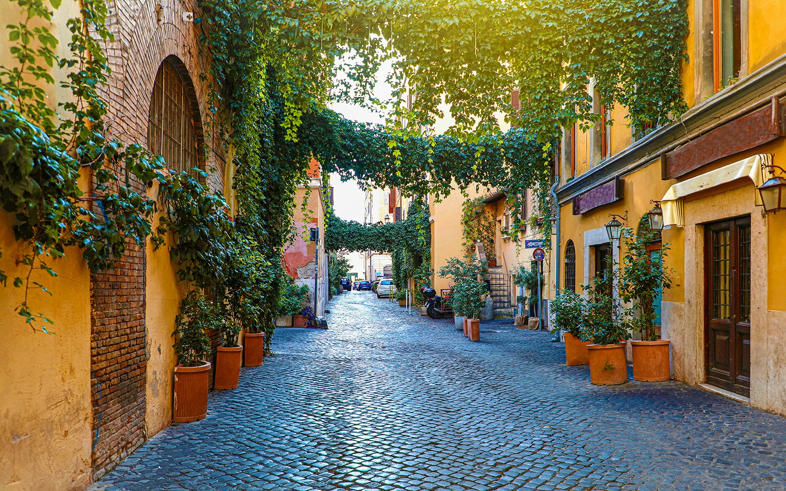 Trastevere old street with cobblestone path and colorful buildings in Rome, Italy.